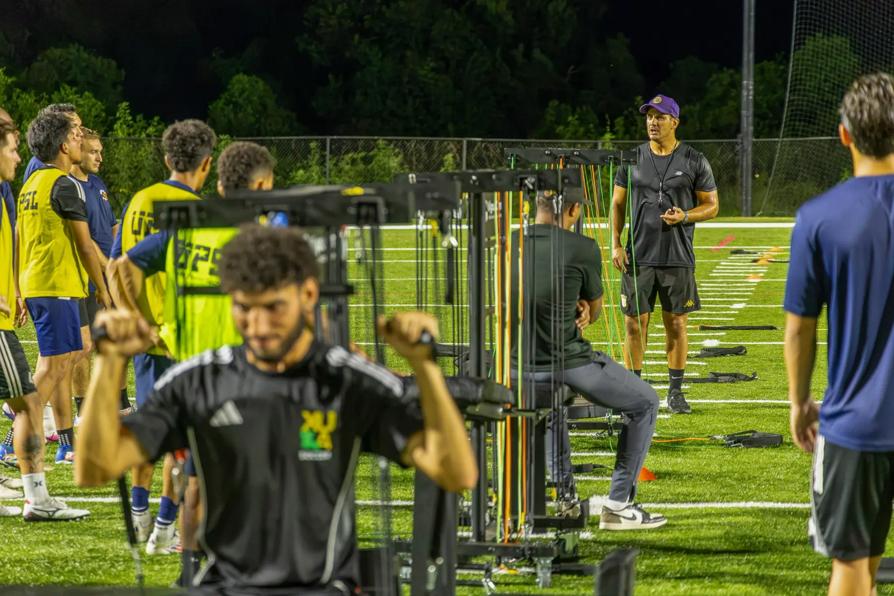 Semi-professional soccer players completing strength work while their coach leads a VigourGym session